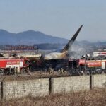 bagian-ekor-pesawat-boeing-737-800-seri-jeju-air-terlihat-di-samping-kendaraan-penyelamat-setelah-pesawat-jatuh-dan-terbakar-d