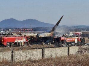 bagian-ekor-pesawat-boeing-737-800-seri-jeju-air-terlihat-di-samping-kendaraan-penyelamat-setelah-pesawat-jatuh-dan-terbakar-d